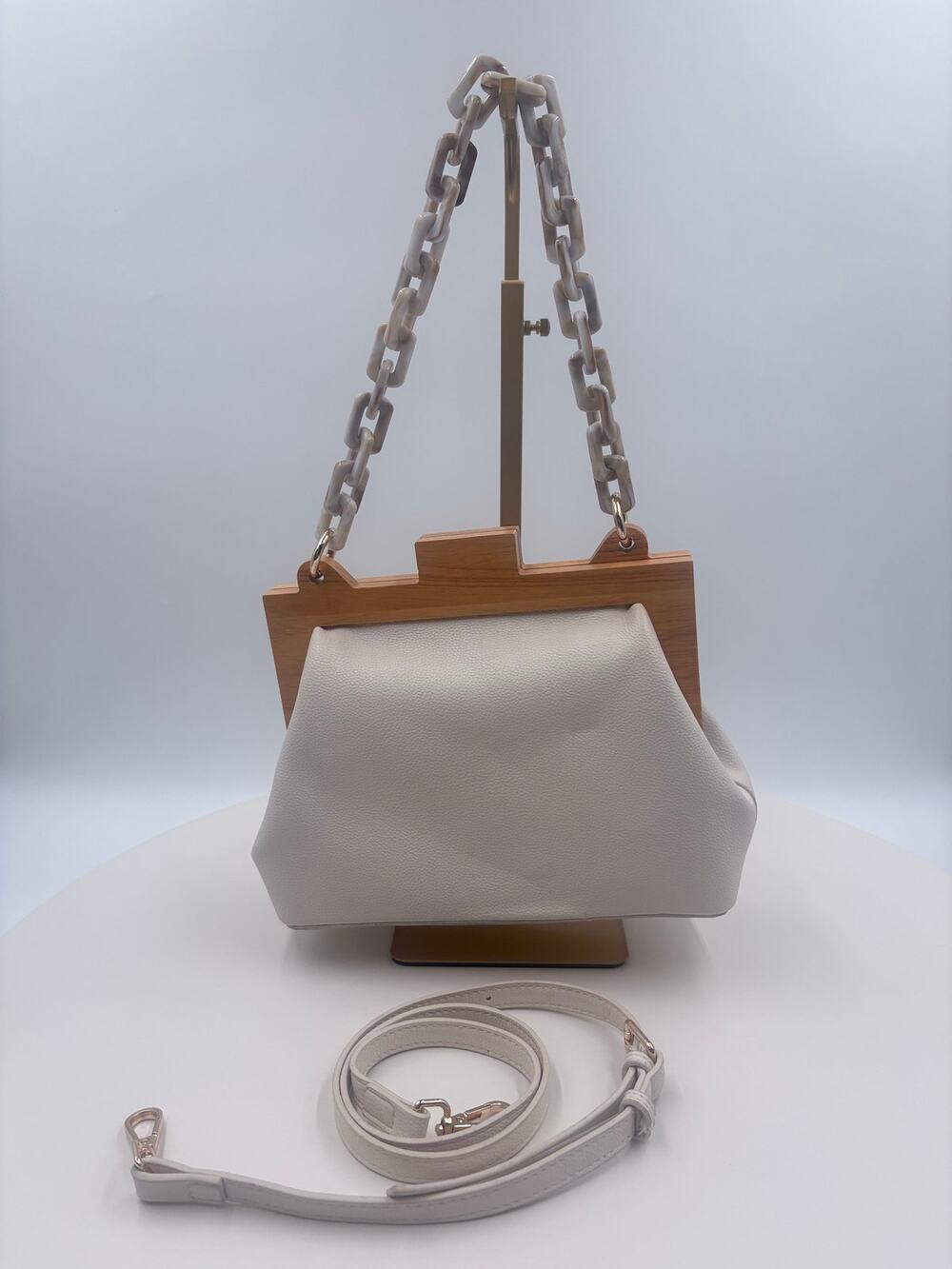 Cream color handbag with crossbody strap and handbag strap